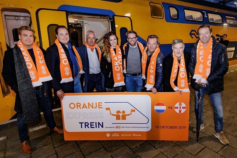 Aan boord van de Oranje Express werden de supporters getrakteerd door een voorbeschouwing van cabaretier Viggo Waas (tweede van rechts). Foto: KNVB Media