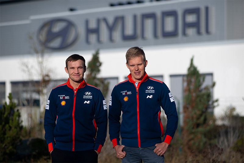 Ott Tänak (rechts) en Martin Järveoja voor het hoofdkantoor van Hyundai Motorsport in Alzenau.