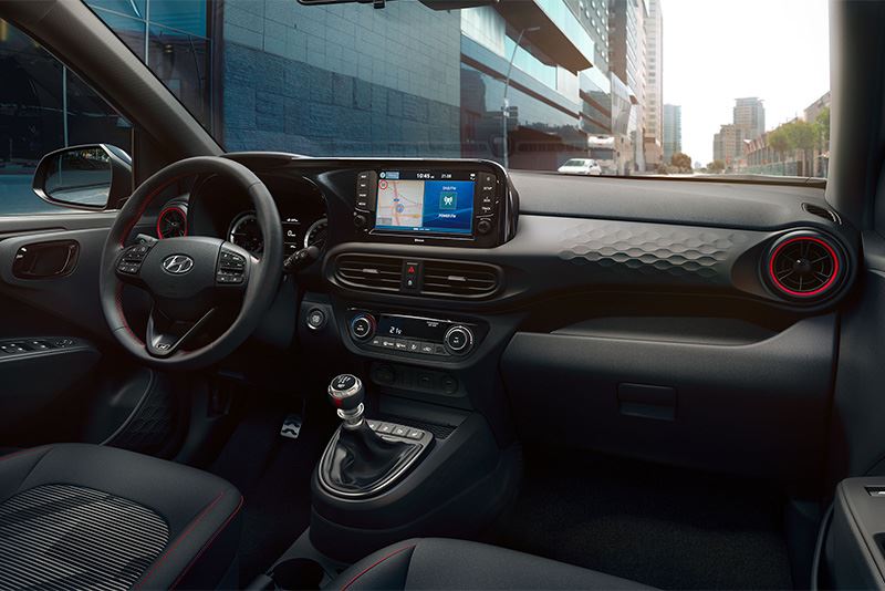 Het interieur van de Hyundai i10 N Line met rode ringen rond de ventilatieroosters.